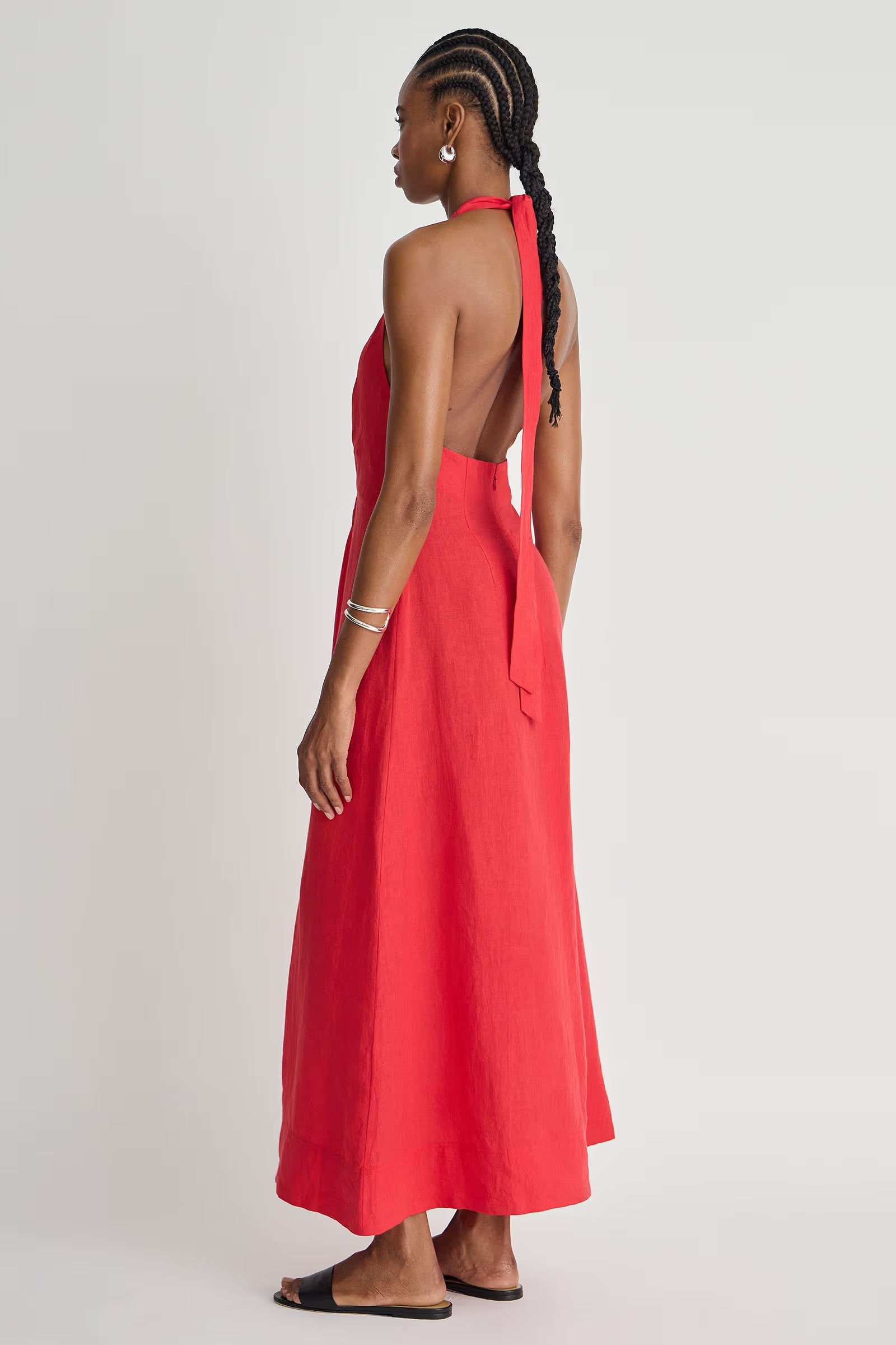 Woman wearing a red halter neck dress with a white background