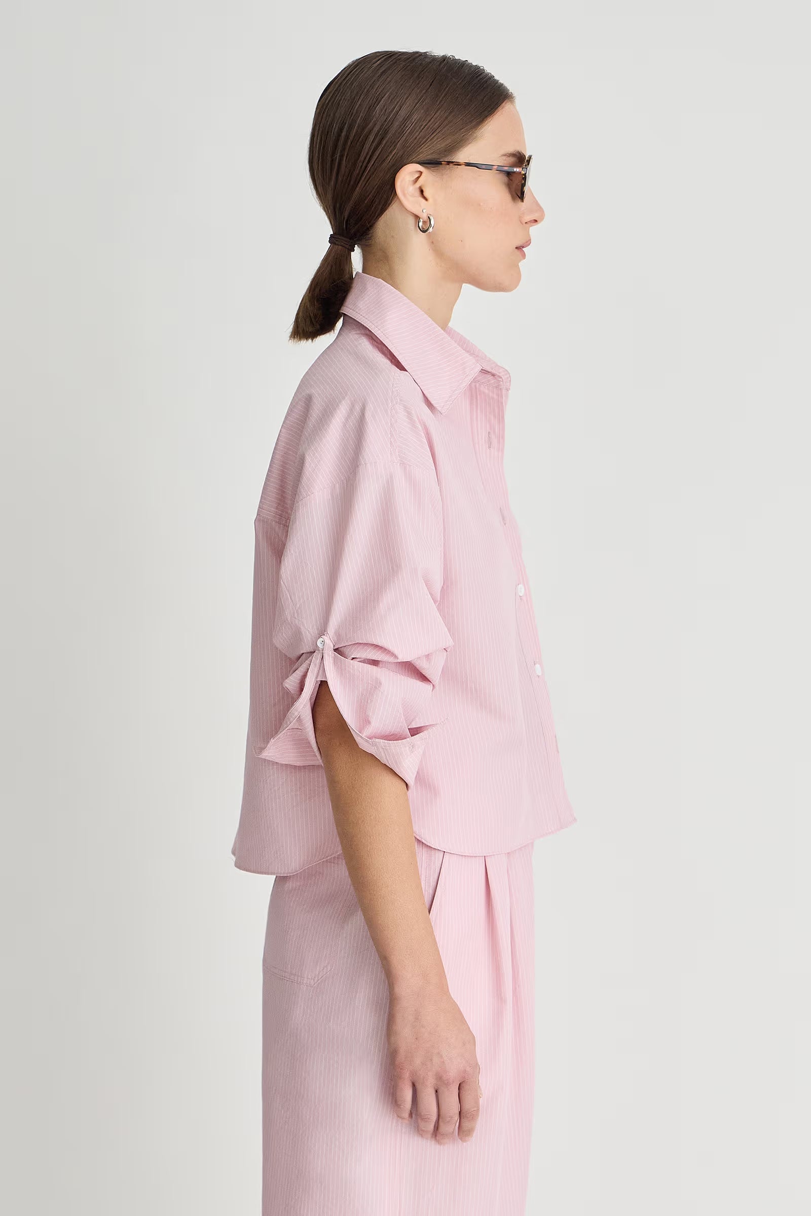 Woman wearing a pink outfit with a plain background