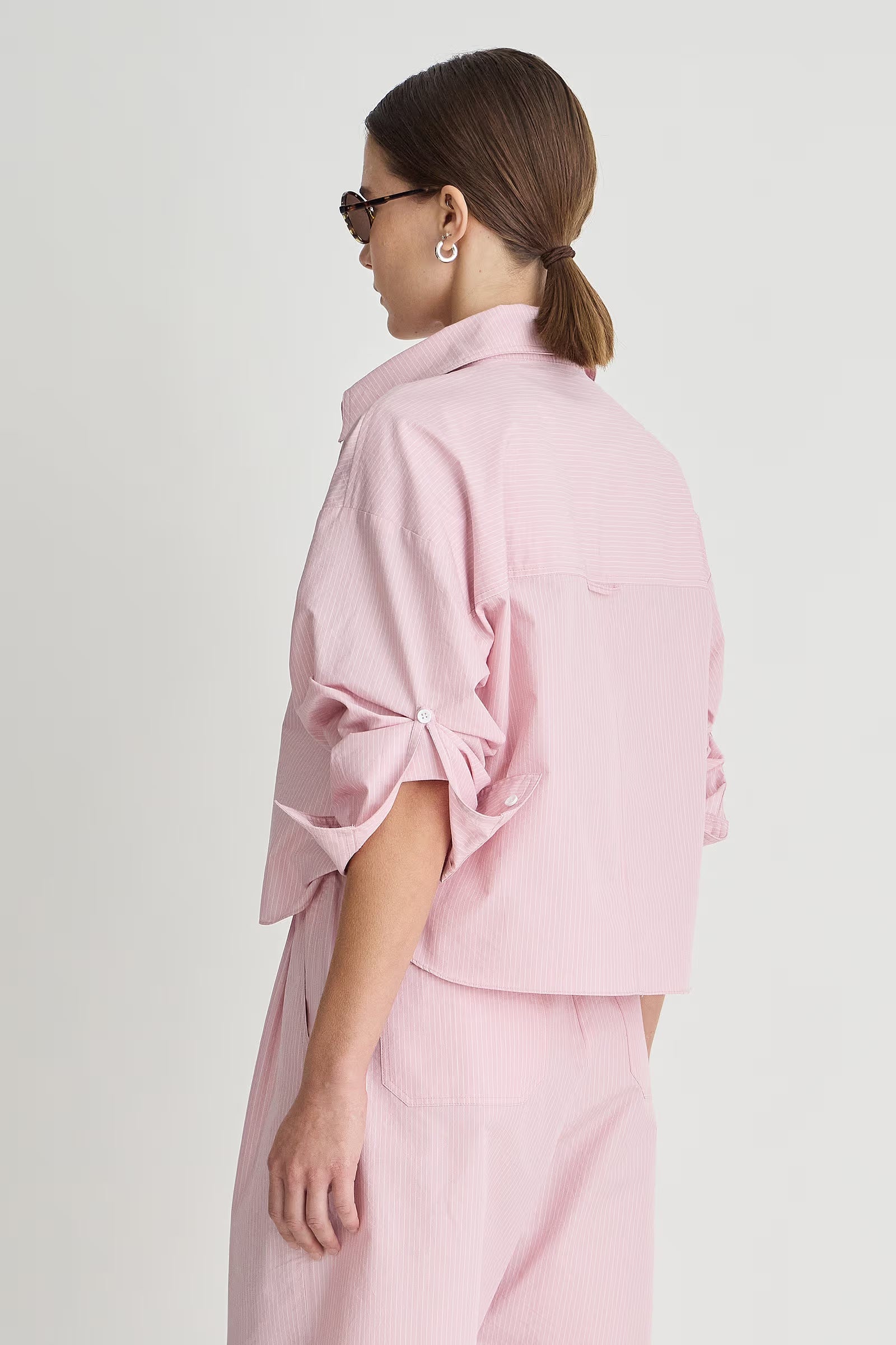 Woman wearing a pink outfit on a white background