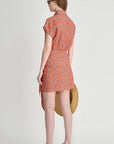Woman wearing a red patterned dress on a white background