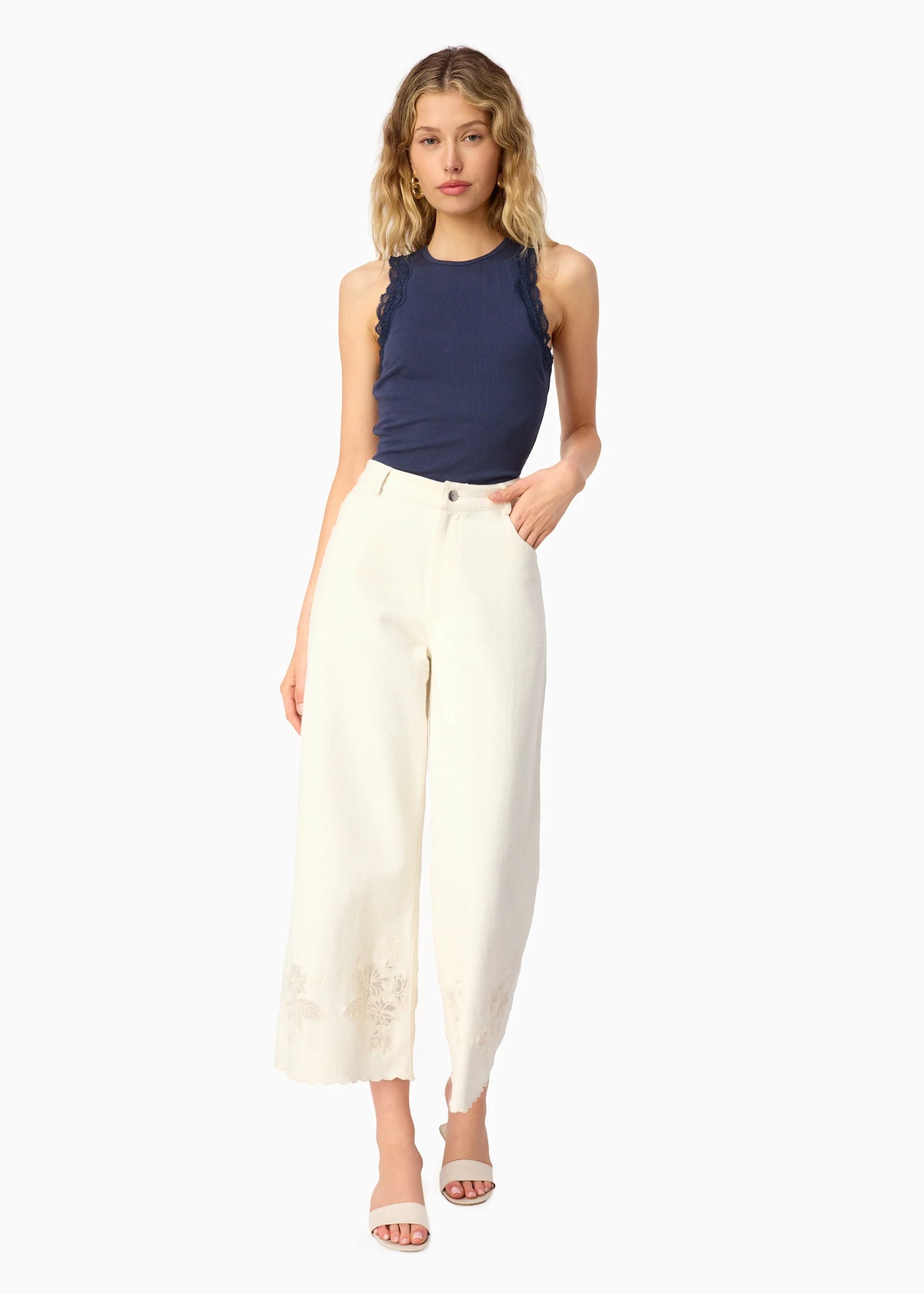 model wearing a high neck lace trim tank with white bottoms on a white background
