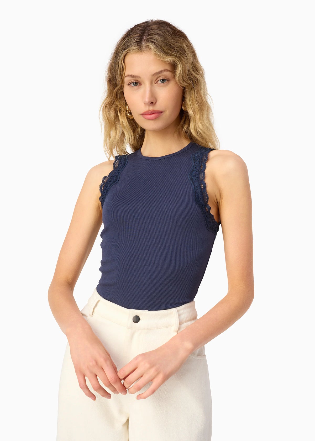 model wearing a high neck lace trim tank with white bottoms on a white background
