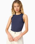 model wearing a high neck lace trim tank with white bottoms on a white background