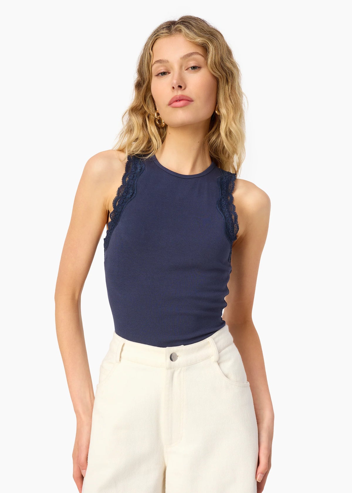 model wearing a high neck lace trim tank with white bottoms on a white background