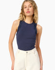 model wearing a high neck lace trim tank with white bottoms on a white background