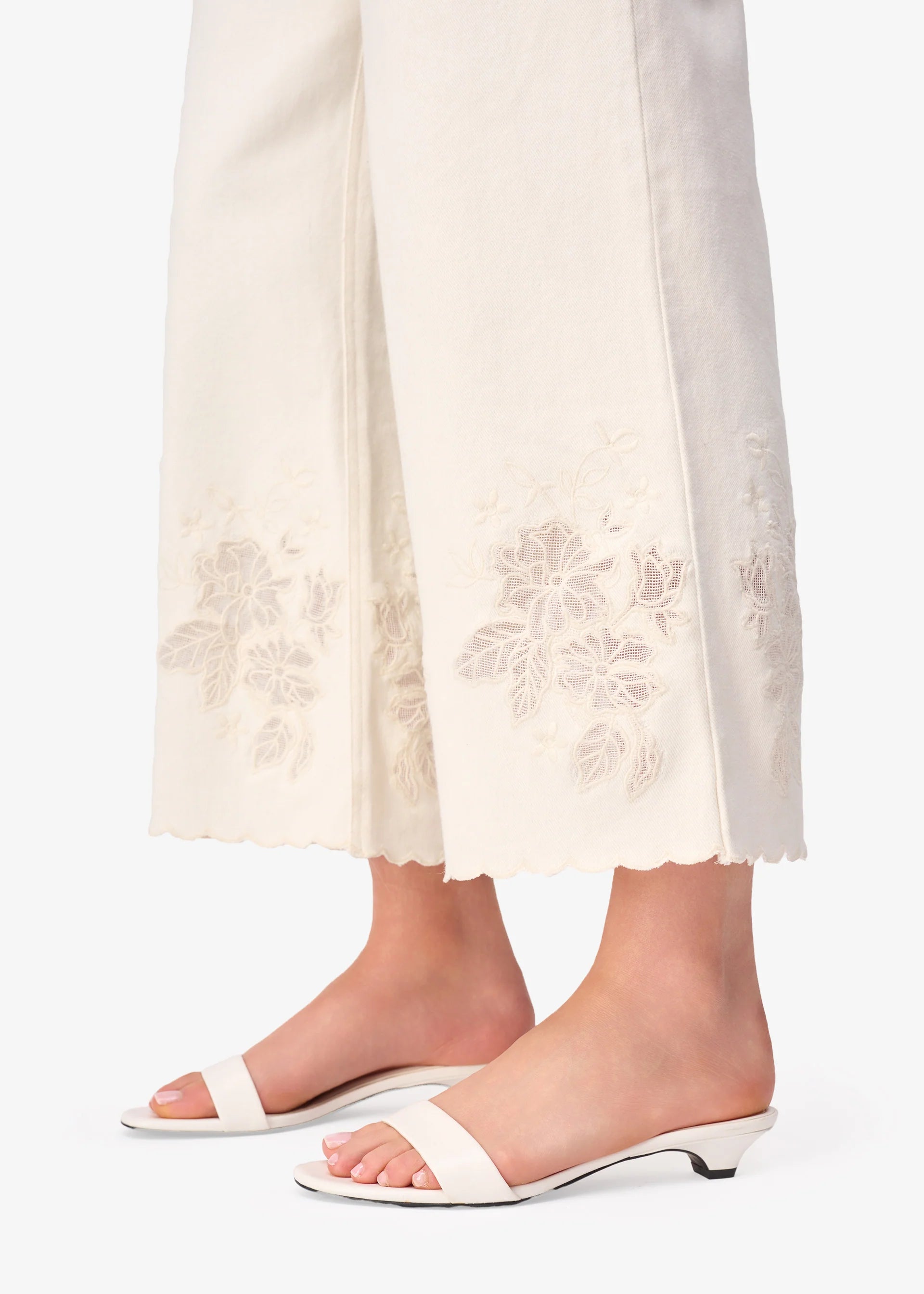 White sandals worn with white pants on a white background