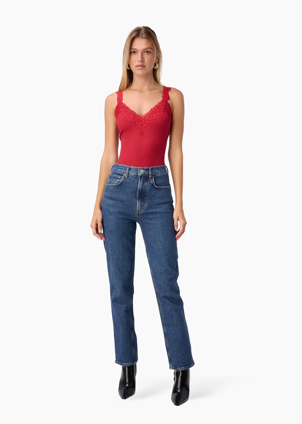 Woman wearing a red top and blue jeans on a white background