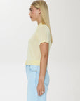 Person wearing a light yellow t-shirt and light blue jeans on a white background