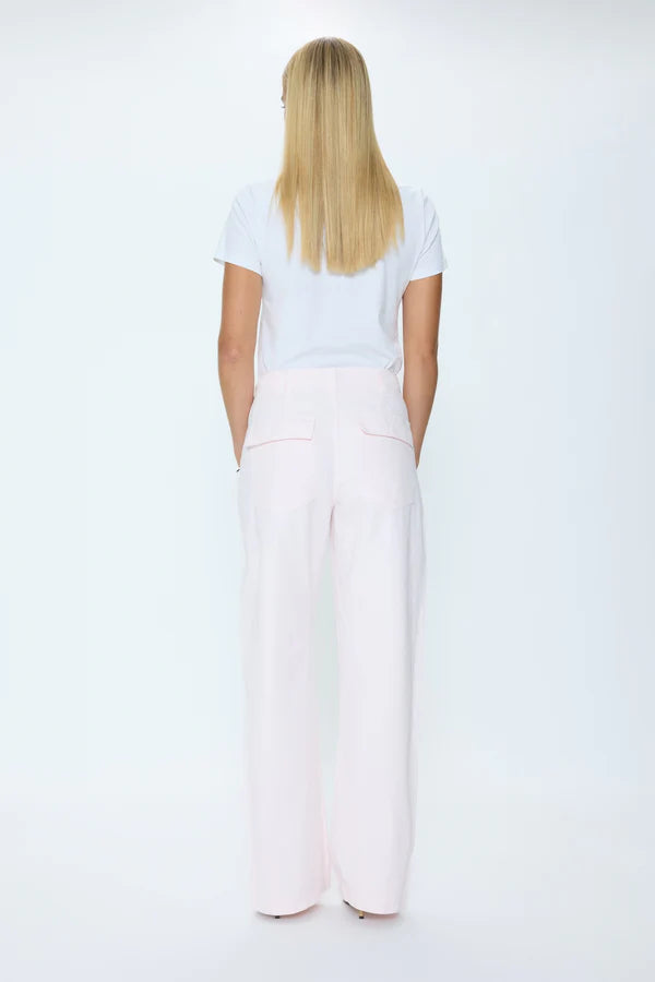 Person wearing a white t-shirt and light pink wide-leg pants on a white background