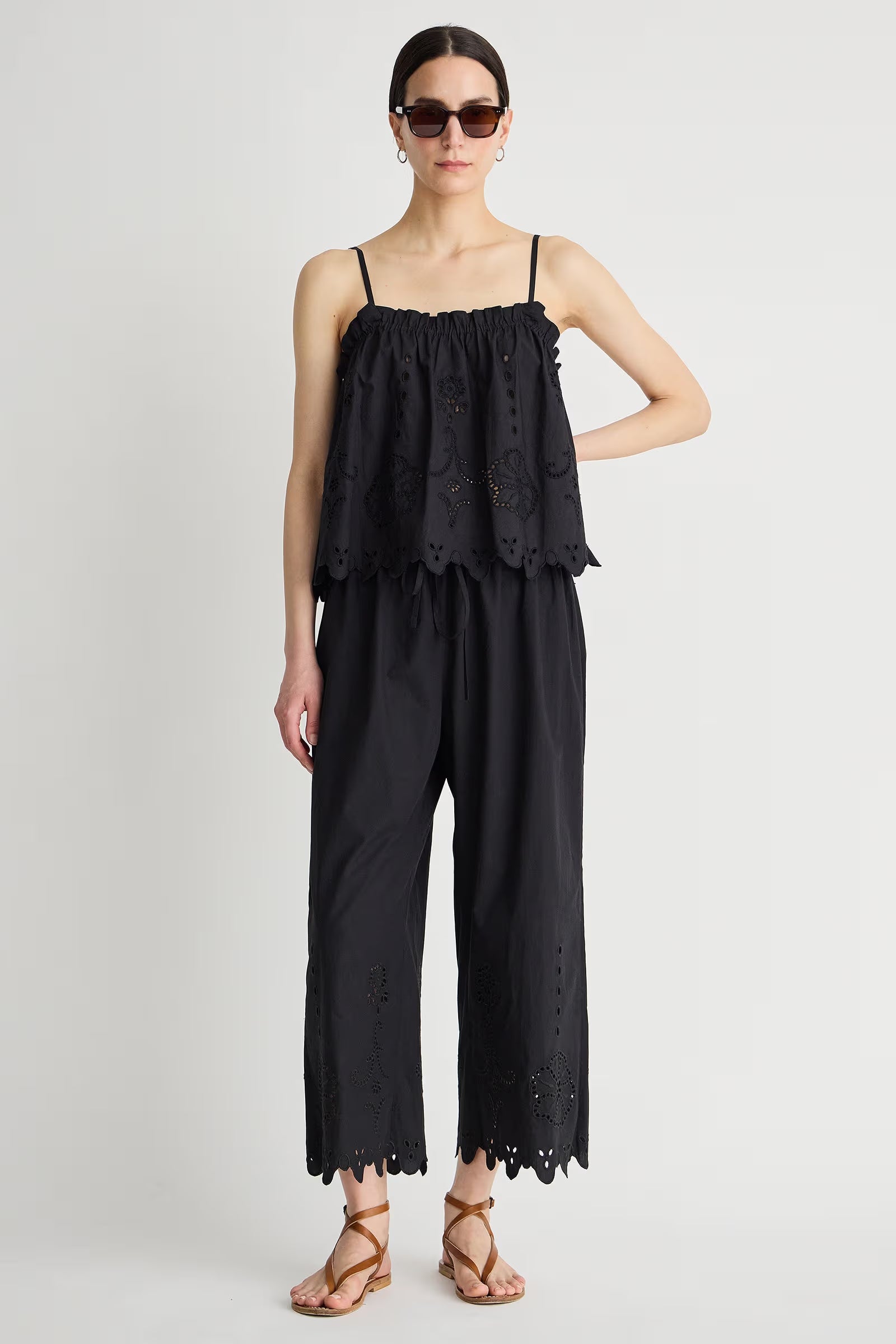 Woman wearing a black lace jumpsuit on a white background