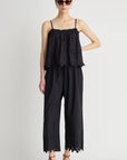 Woman wearing a black lace jumpsuit on a white background