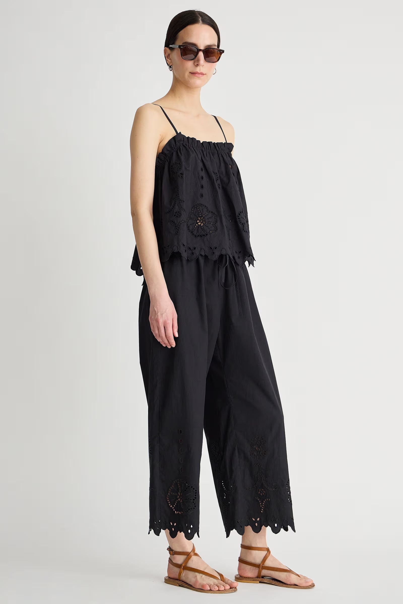 Woman wearing a black lace jumpsuit on a white background