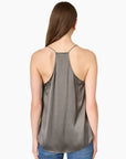 model wearing a gunmetal colored racerback cami with a lace trim and blue jeans on a white background, back view 