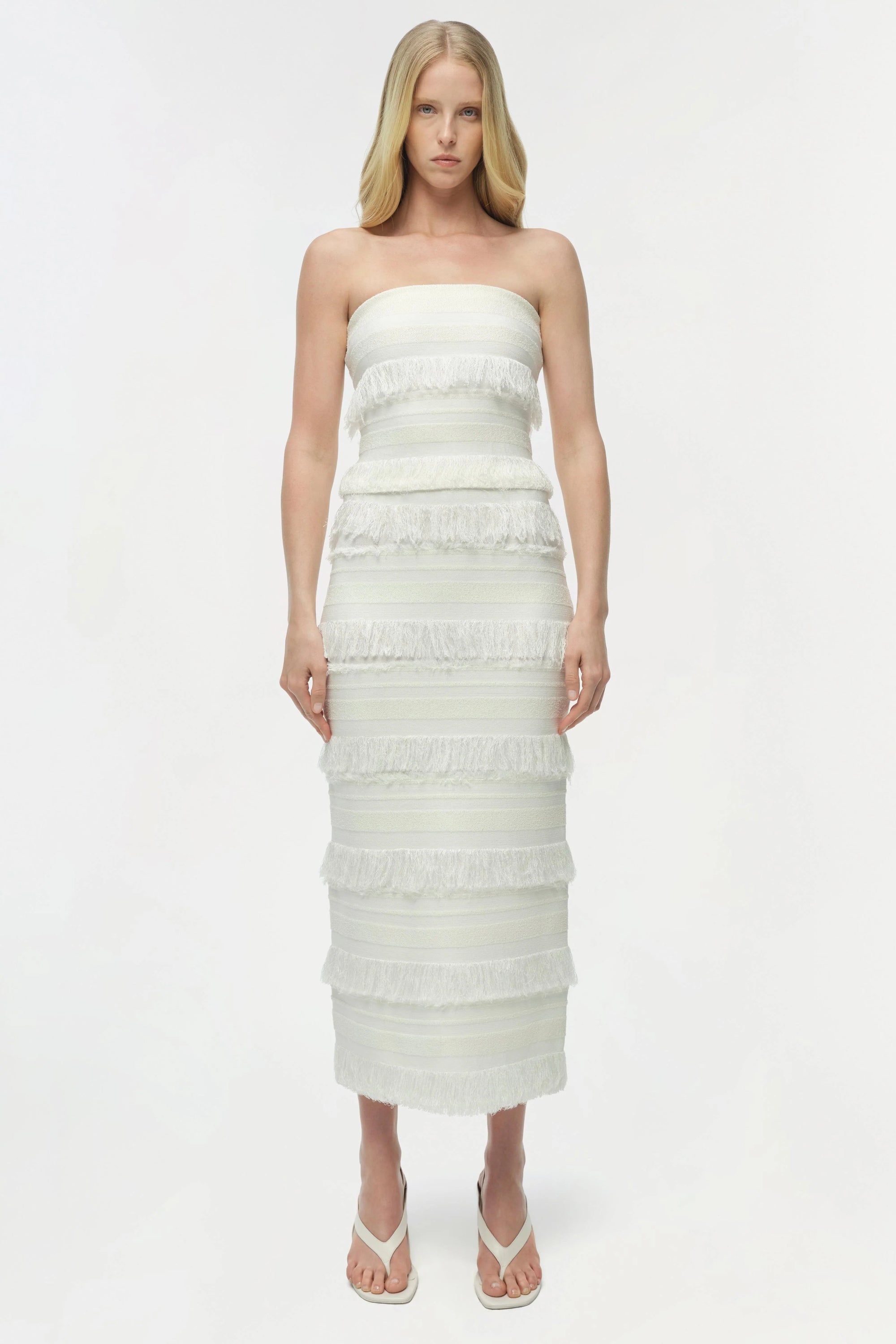 Woman wearing a strapless white dress on a white background