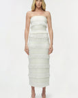 Woman wearing a strapless white dress on a white background