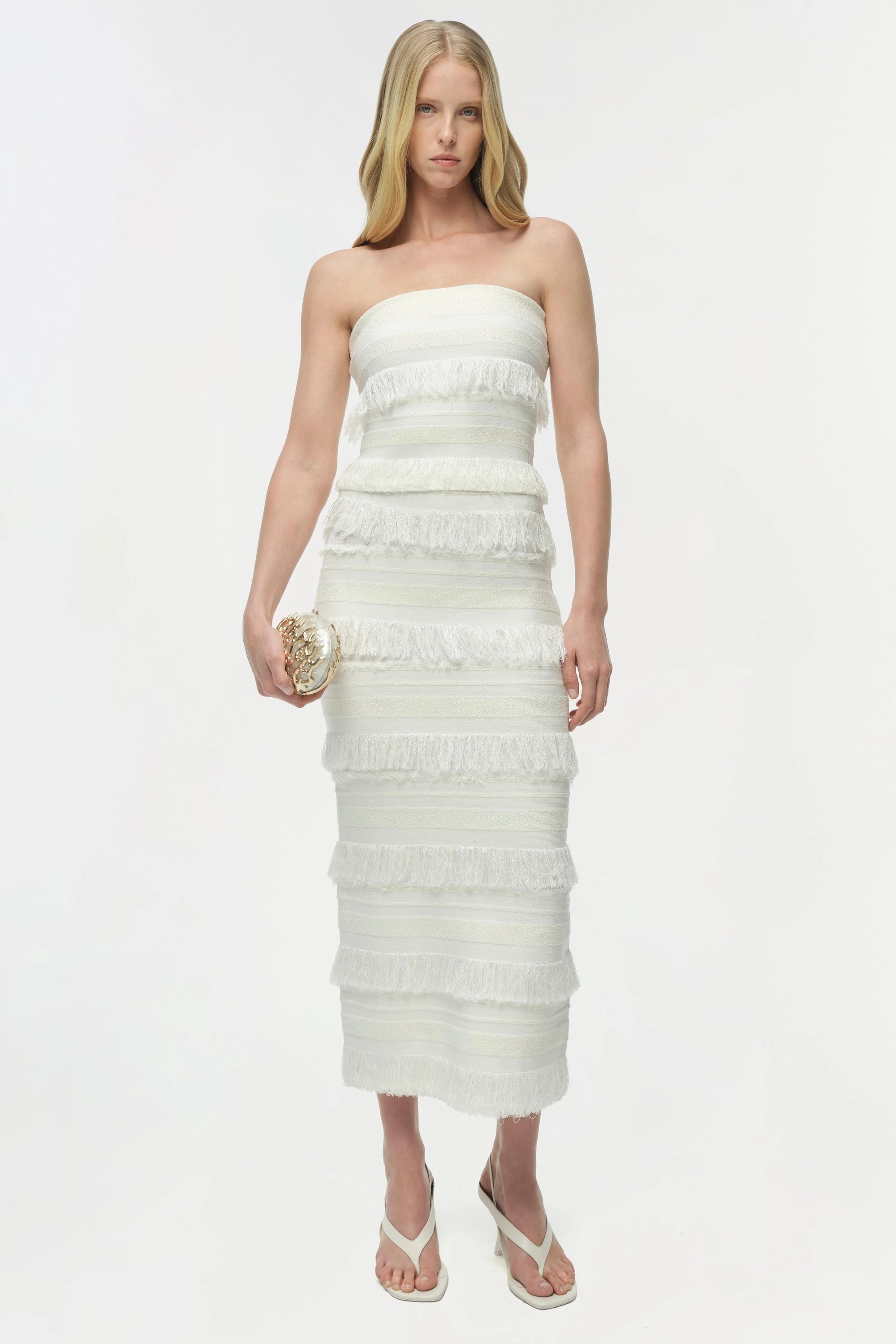 Woman wearing a strapless white dress on a white background