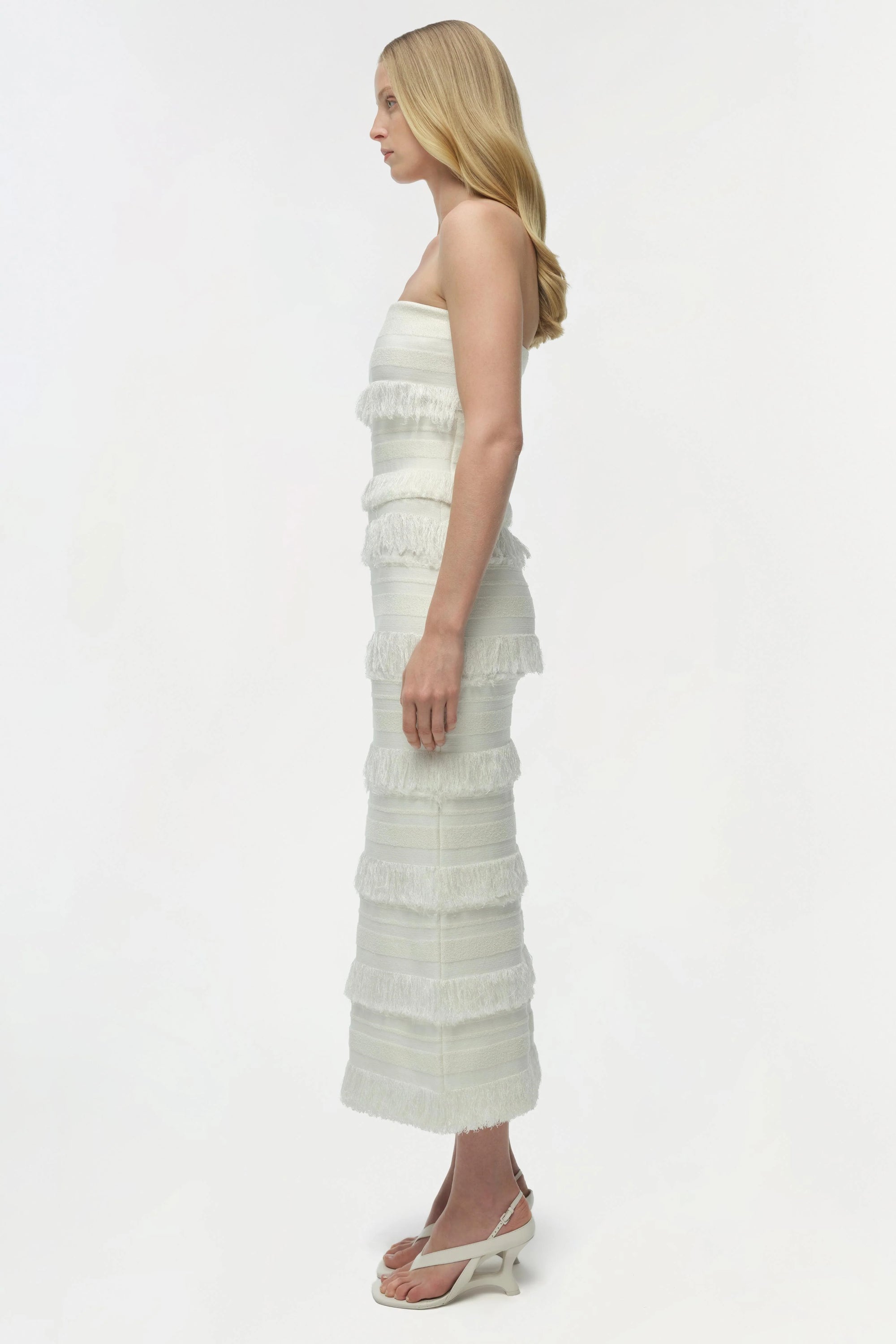 Woman wearing a white strapless dress on a white background