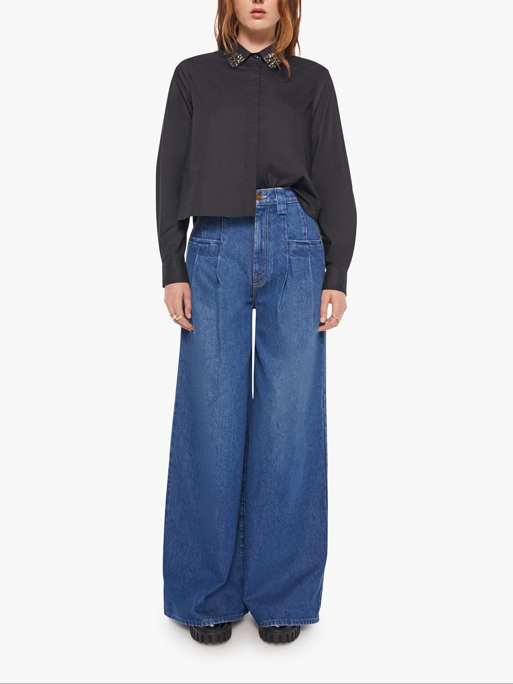 Person wearing a black shirt and blue jeans on a white background