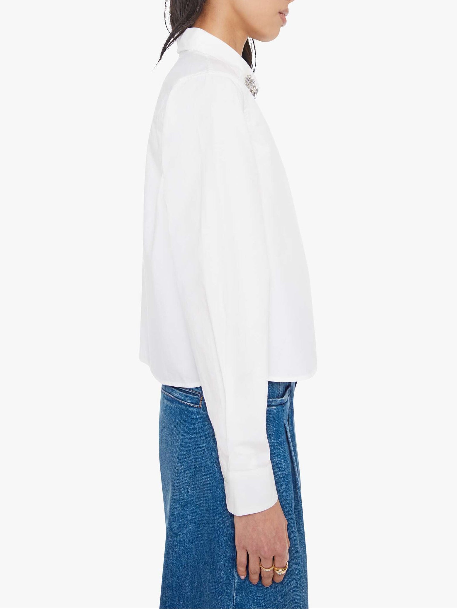 Woman wearing a white blouse and blue jeans on a white background