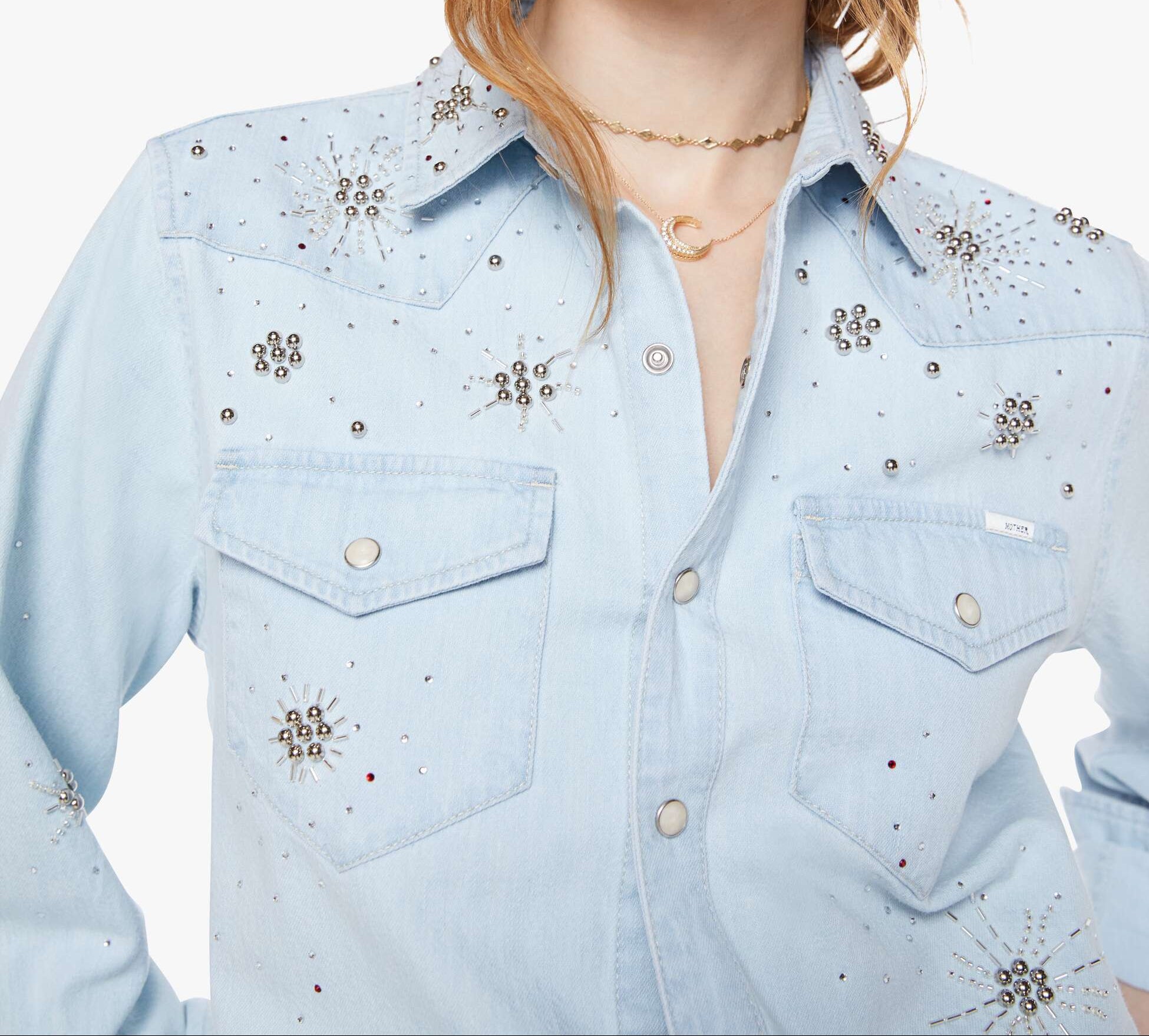 Light blue denim shirt with floral embellishments worn by a model on a white background
