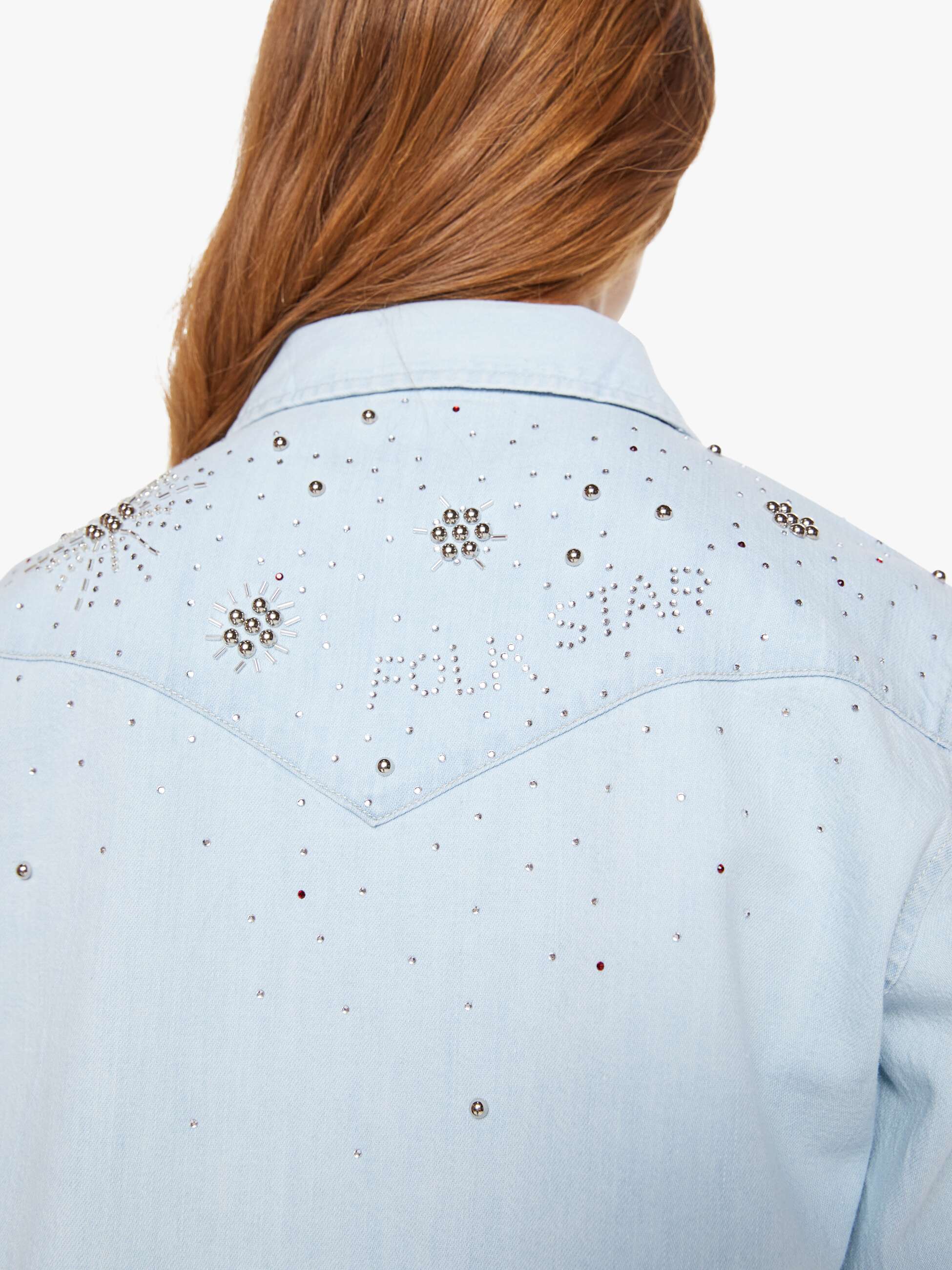 Light blue denim jacket with decorative studs on a white background