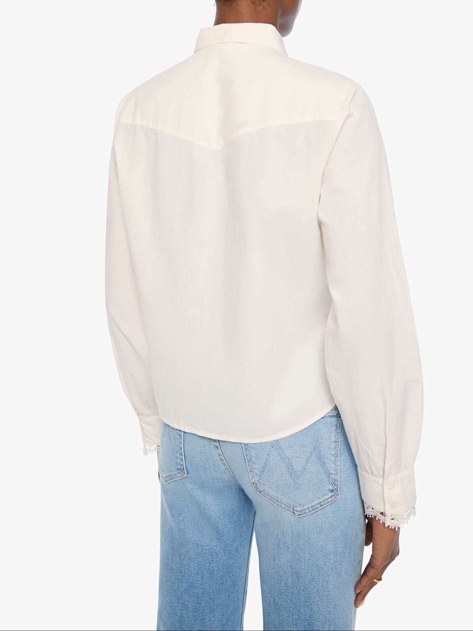 Person wearing a white blouse and blue jeans on a white background