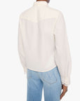 Person wearing a white blouse and blue jeans on a white background