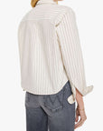 Woman wearing a white striped shirt and gray jeans on a white background