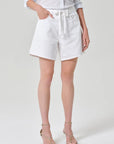 Person wearing white shorts on a plain background