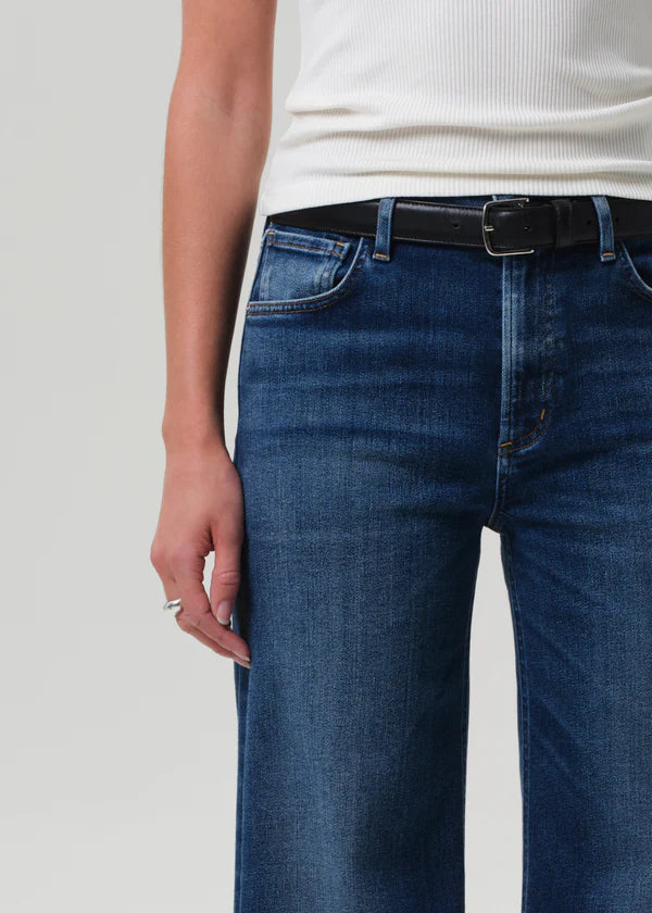 Person wearing blue jeans with a white background