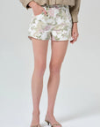 Person wearing floral shorts on a plain background