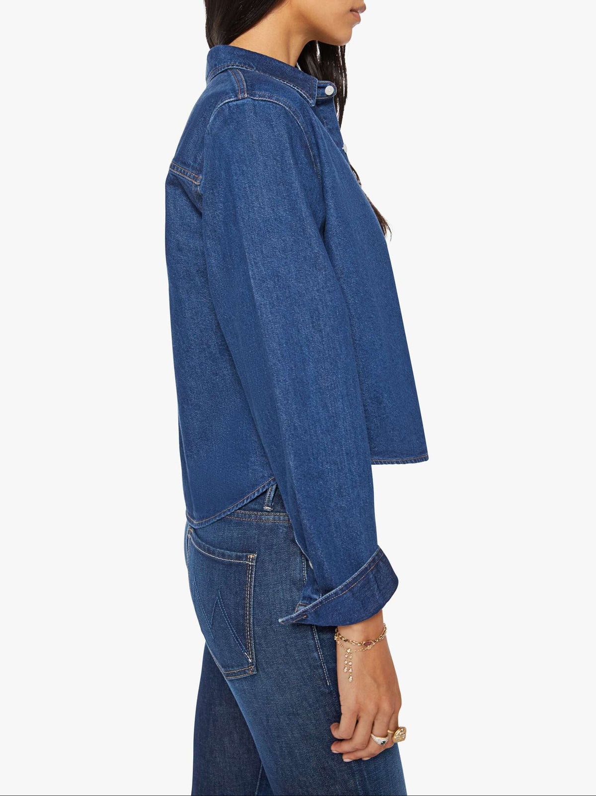 Woman wearing a blue denim jacket and jeans on a white background
