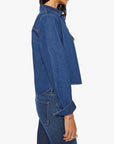 Woman wearing a blue denim jacket and jeans on a white background