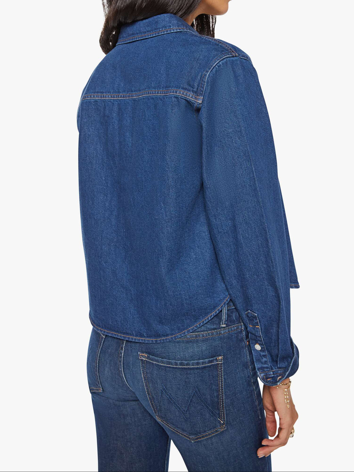 Woman wearing a blue denim jacket and jeans on a white background