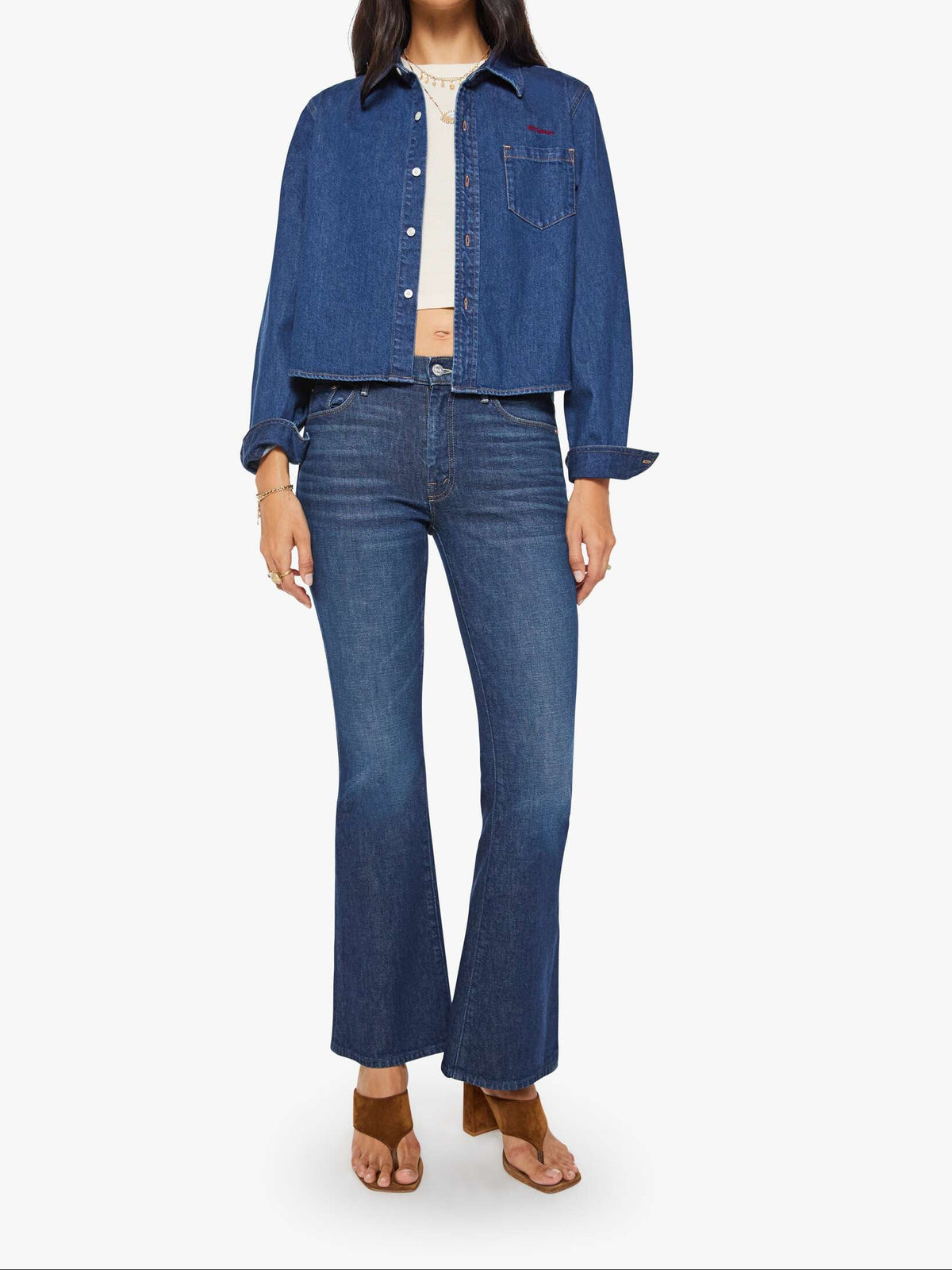 Woman wearing a blue denim jacket and jeans on a white background