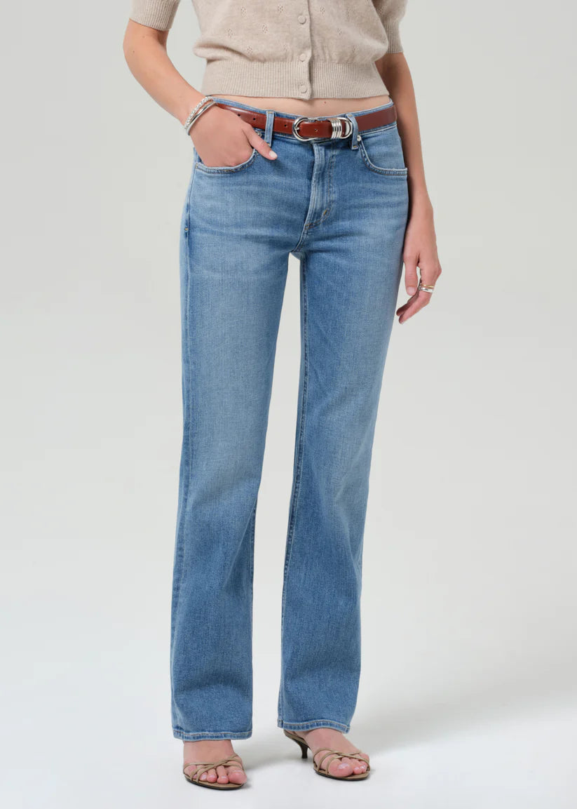 Person wearing blue jeans with a plain background