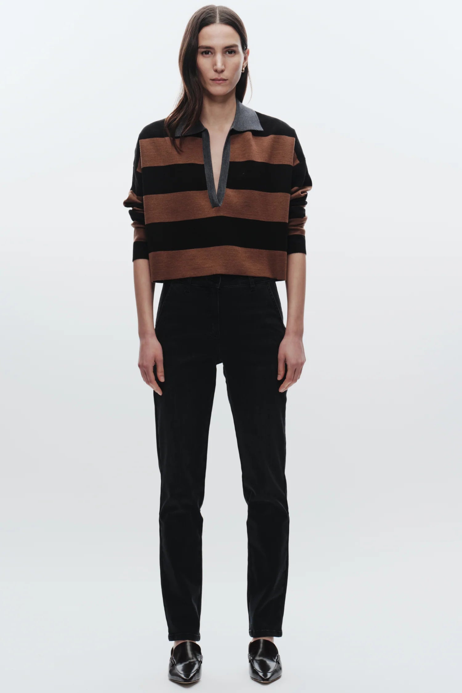 Person wearing a black and brown striped shirt with a white background, full body