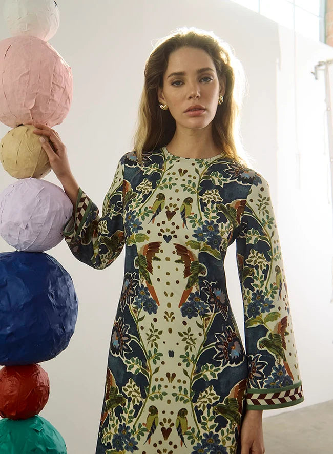 model wearing a print dress with art balls around her and a white background