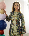 model wearing a print dress with art balls around her and a white background