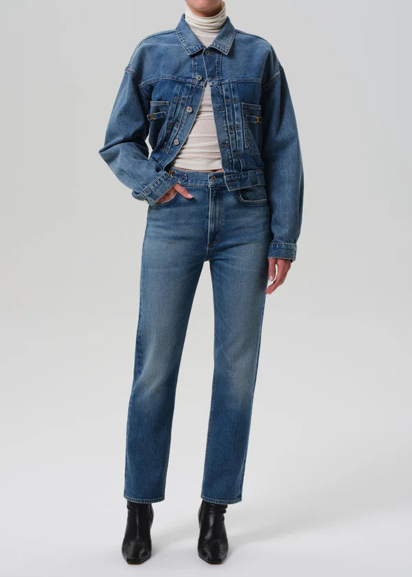 Person wearing a blue denim jacket and jeans on a white background front view
