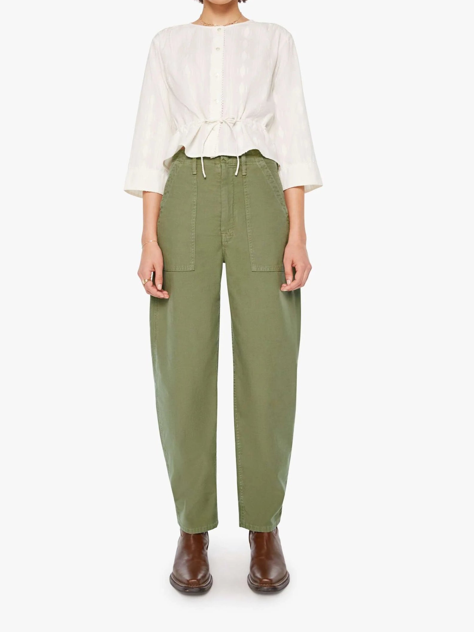 Woman wearing a white blouse and green pants on a white background, full body front