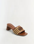 Brown sandal with woven design and wooden block heel on a light gray background