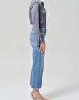 Person wearing a gray shirt and blue jeans on a white background