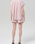 Person wearing a pink striped outfit on a white background
