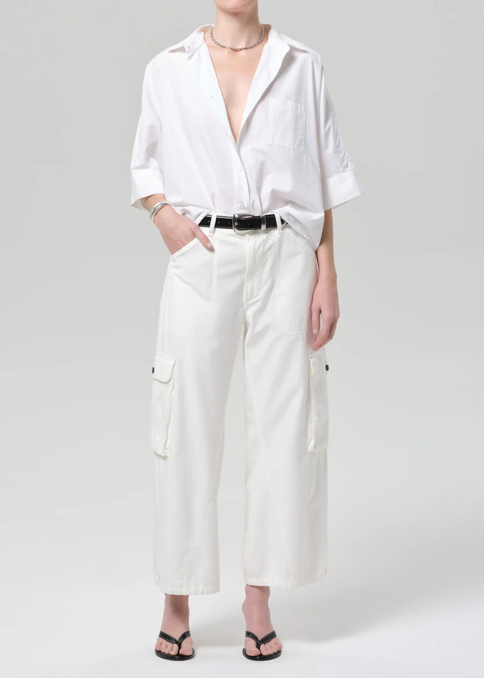 Person wearing a white shirt and wide-leg pants on a plain background