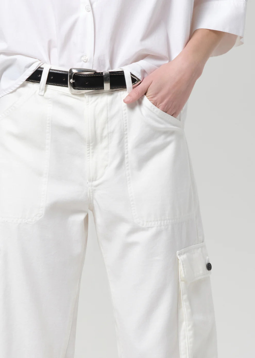 White pants with a black belt on a plain background