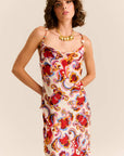 Woman wearing a colorful floral dress against a beige background
