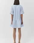 Woman wearing a light blue striped dress on a white background