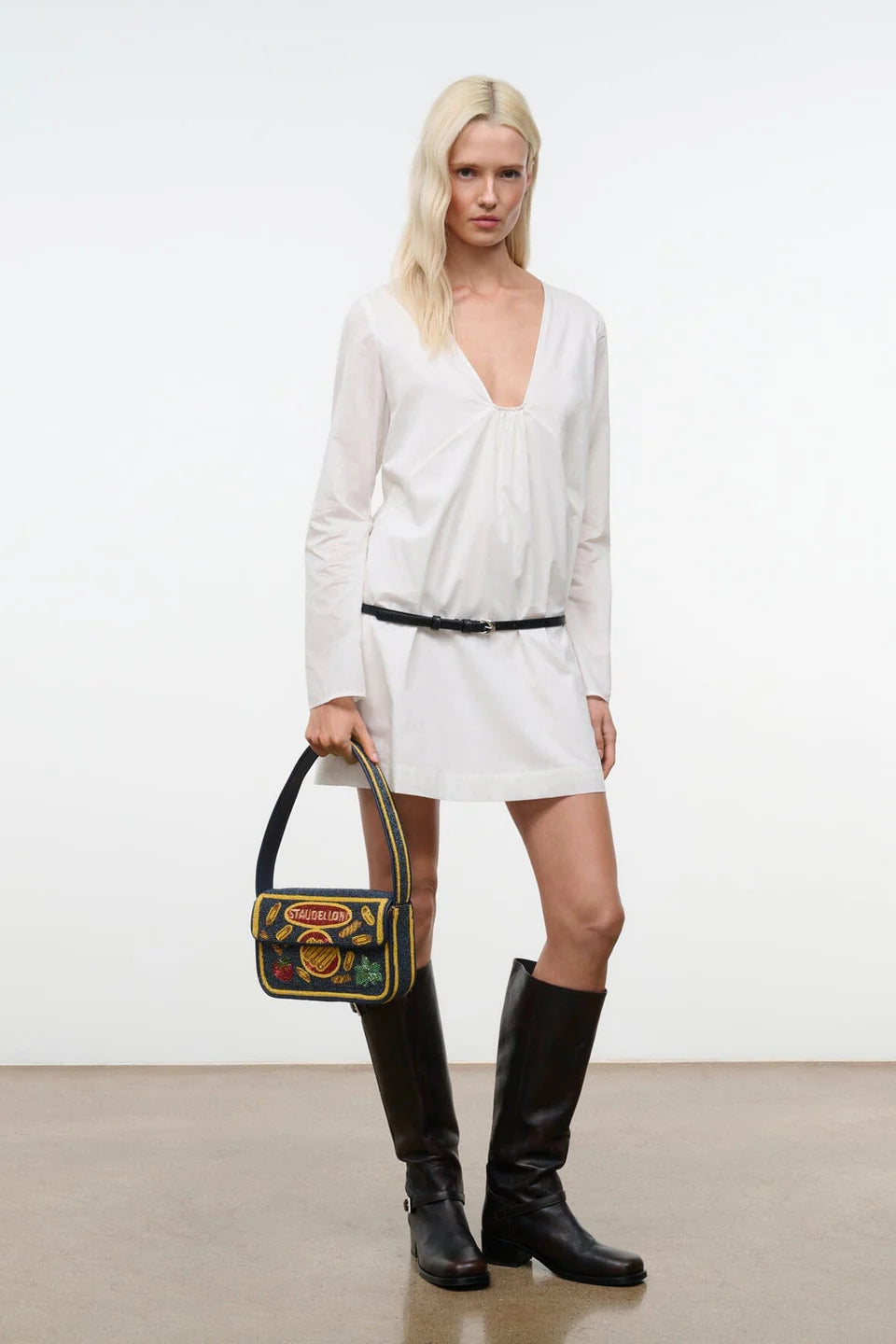 Woman in Vivi Dress holding a colorful handbag against a plain background