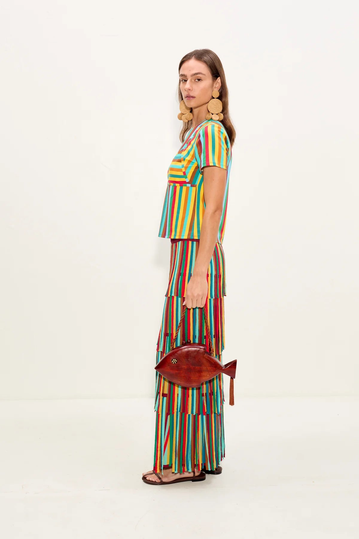 Woman wearing a colorful striped outfit with a white background